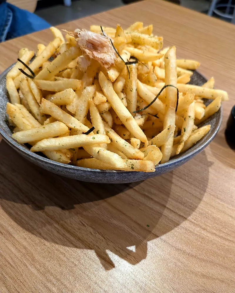A bowl of umami fries with seaweed and bonito flakes, with mayo on the side