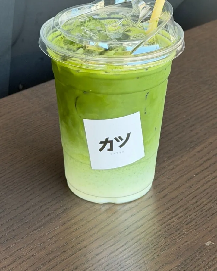 An iced jasmine matcha with the カツ sticker on the cup