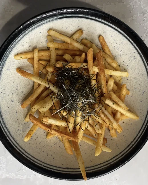A bowl of umami fries topped with seaweed